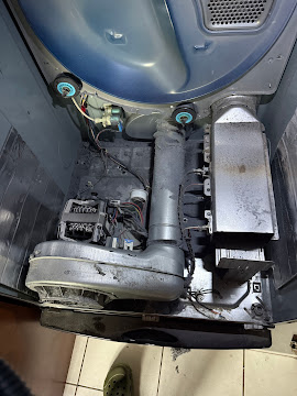Top-load washing machine fully disassembled with motor, transmission, and drain pump exposed during an Express Xpert washer repair in Fort Lauderdale, Broward County, FL