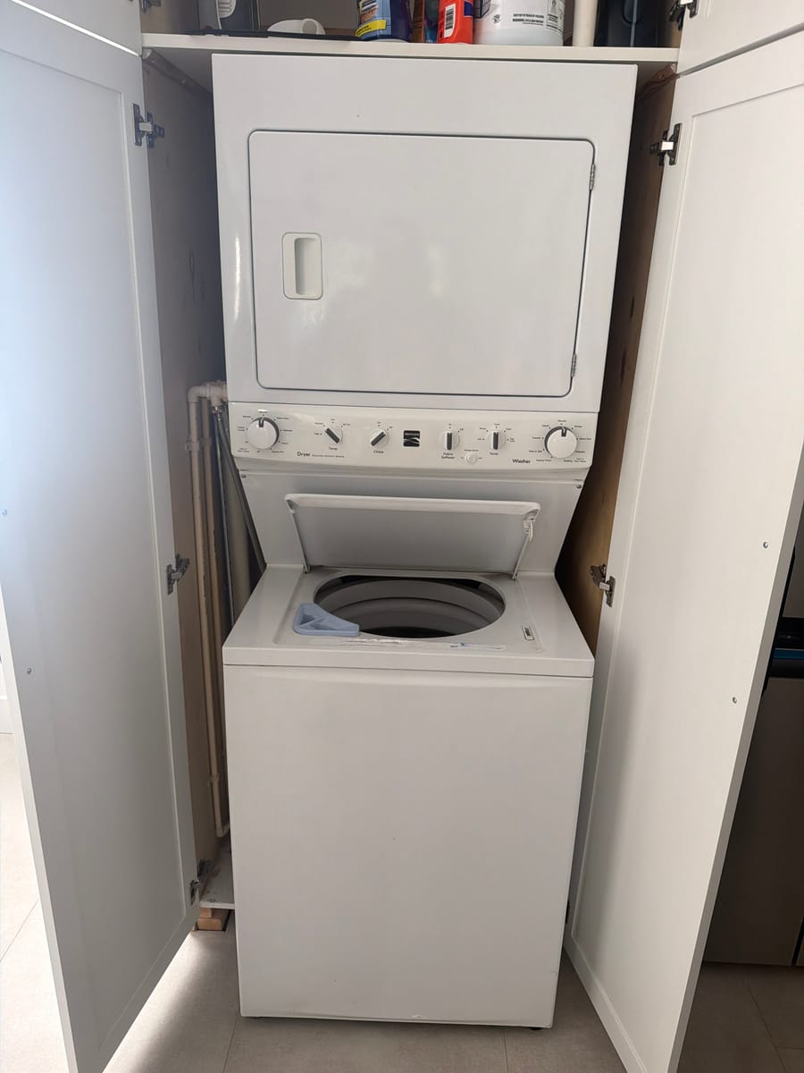 Stacked washer-dryer unit serviced in a Broward County laundry closet