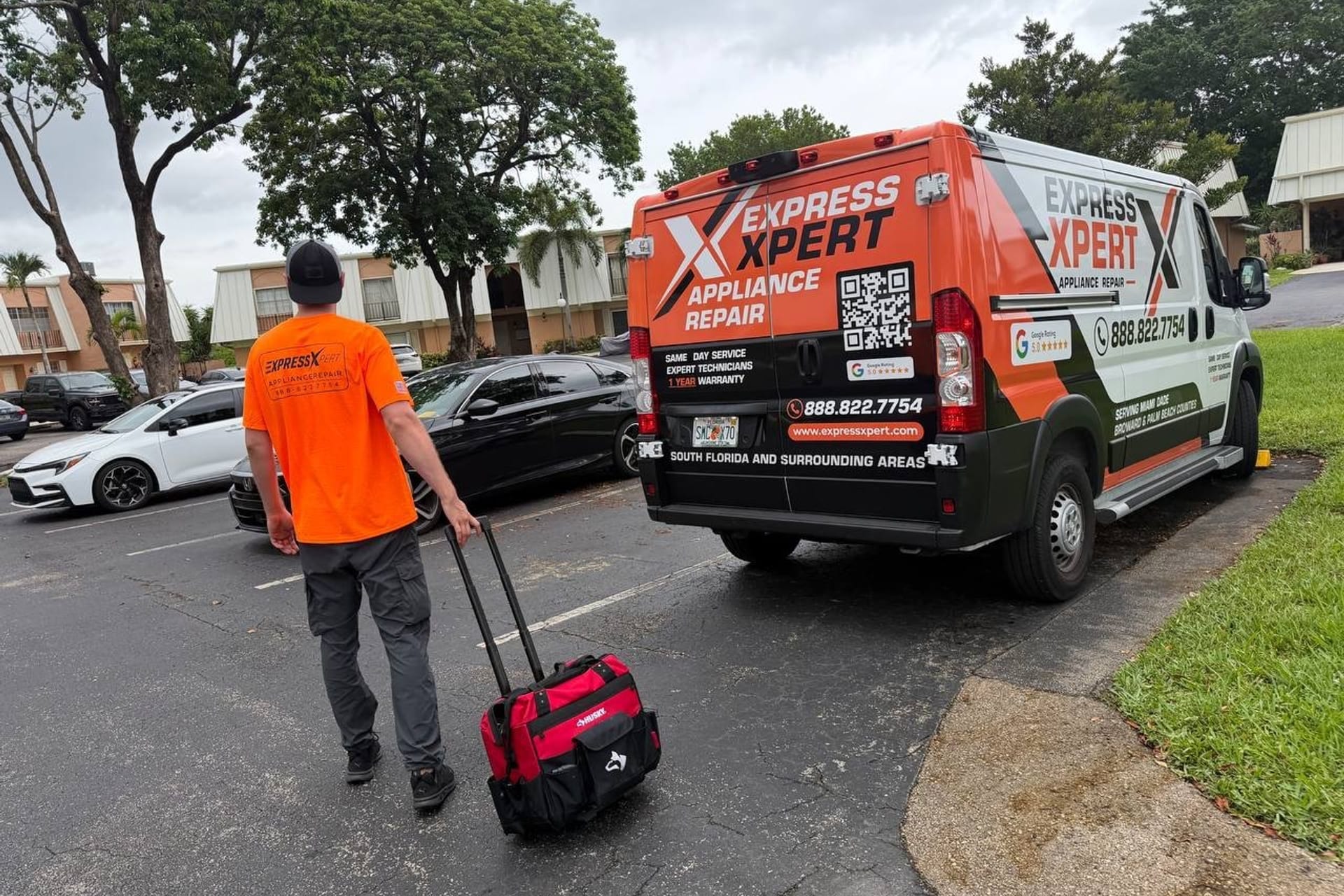 Express Xpert technician arriving with tools at a Miami-Dade home, branded appliance repair van parked alongside