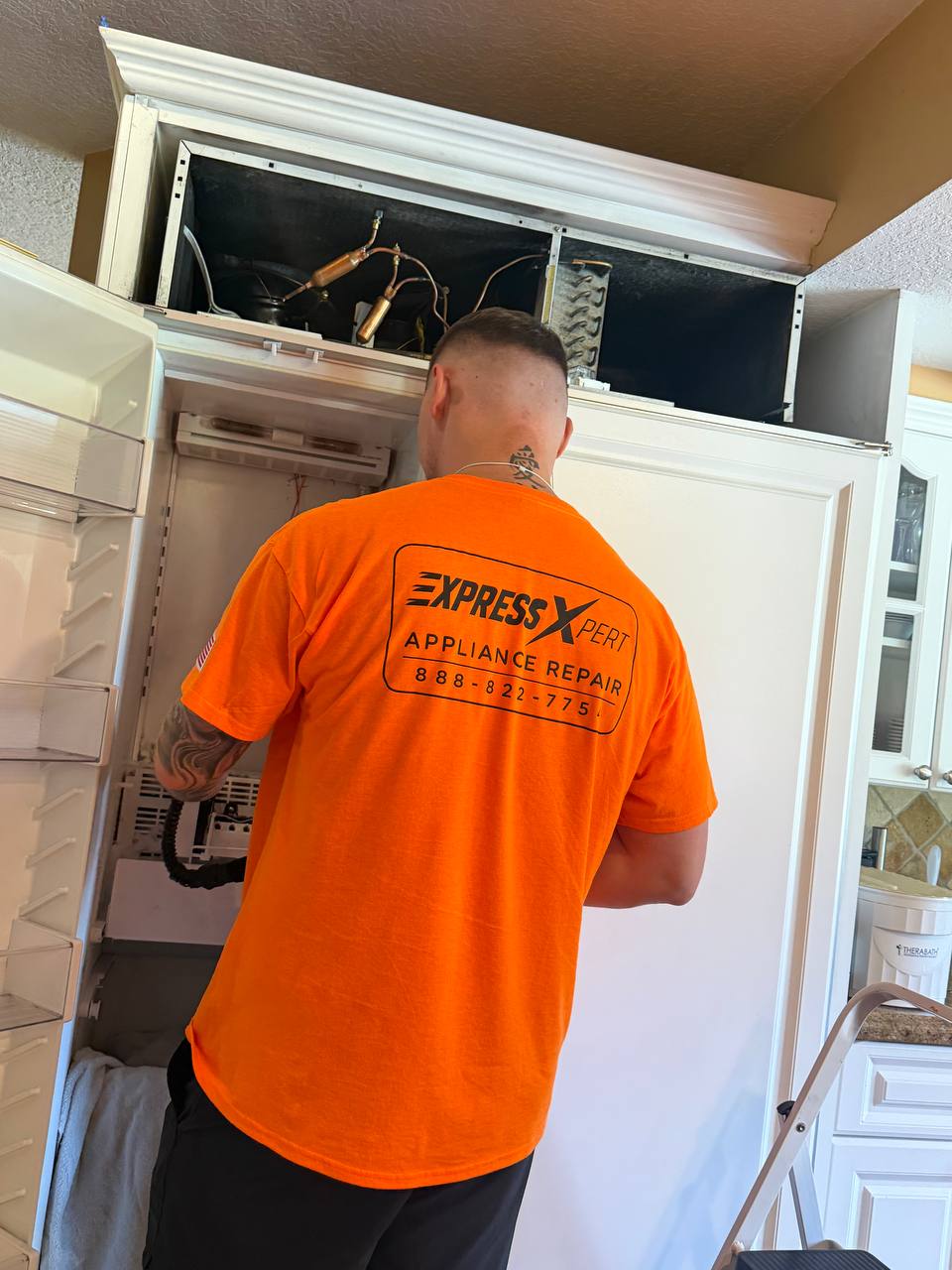Express Xpert technician repairing a refrigerator in a Palm Beach County home